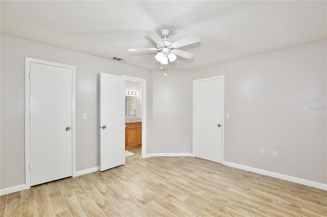 956 Salt Pond Pl Unit 207, Altamonte Springs, FL 32714 - unfurnished bedroom with light wood-style flooring, connected bathroom, baseboards, a ceiling fan, and a textured ceiling