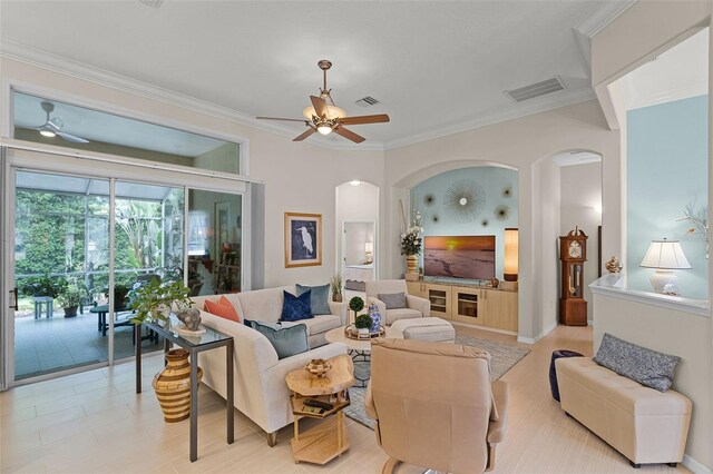 living room with a ceiling fan, visible vents, and arched walkways