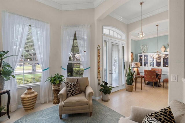 sitting room featuring arched walkways, plenty of natural light, crown molding, and an inviting chandelier
