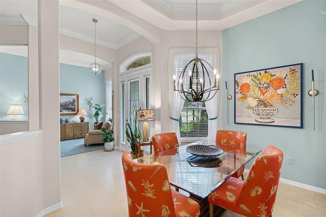 dining area with arched walkways, baseboards, an inviting chandelier, and crown molding