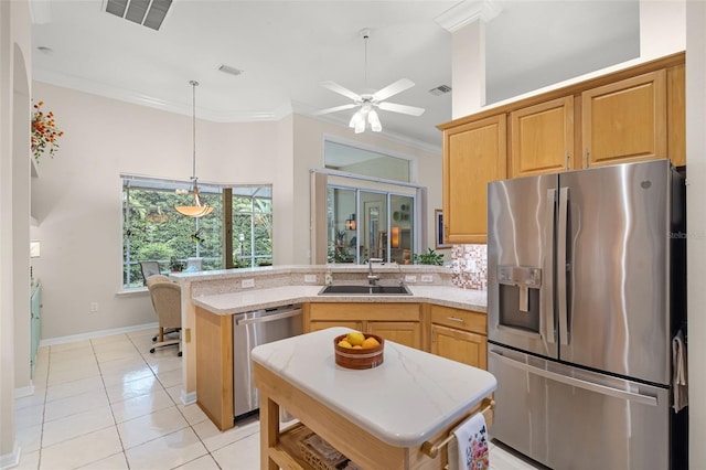 kitchen with visible vents, a sink, crown molding, a peninsula, and appliances with stainless steel finishes