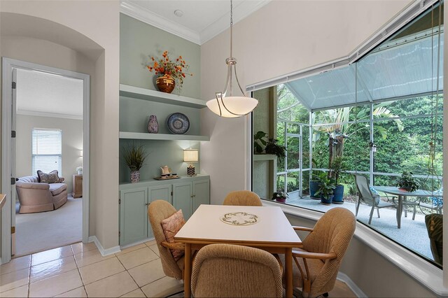 dining space with light colored carpet, crown molding, a sunroom, and light tile patterned flooring