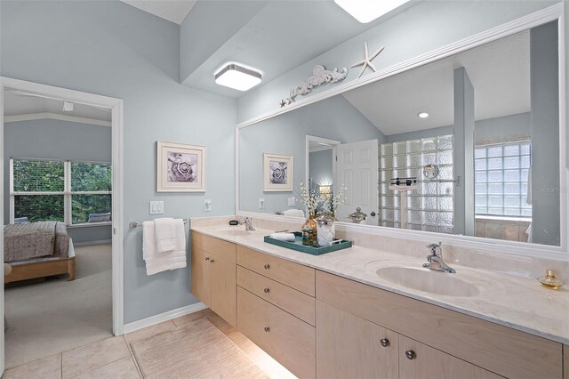 ensuite bathroom featuring plenty of natural light, tile patterned floors, and a sink