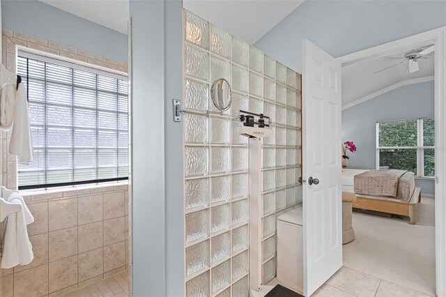 ensuite bathroom featuring vaulted ceiling, tile patterned flooring, ceiling fan, connected bathroom, and a walk in shower