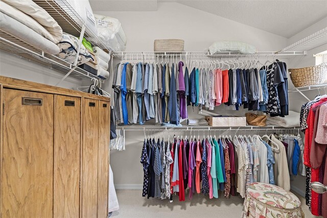 spacious closet with vaulted ceiling and carpet
