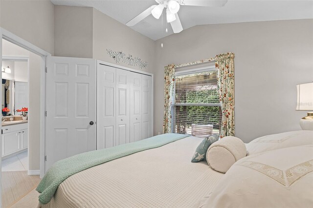 bedroom with lofted ceiling, a sink, light wood-style floors, a closet, and ceiling fan