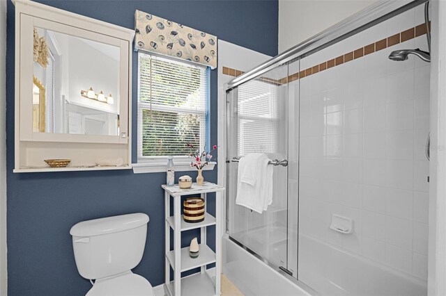 full bathroom with combined bath / shower with glass door and toilet