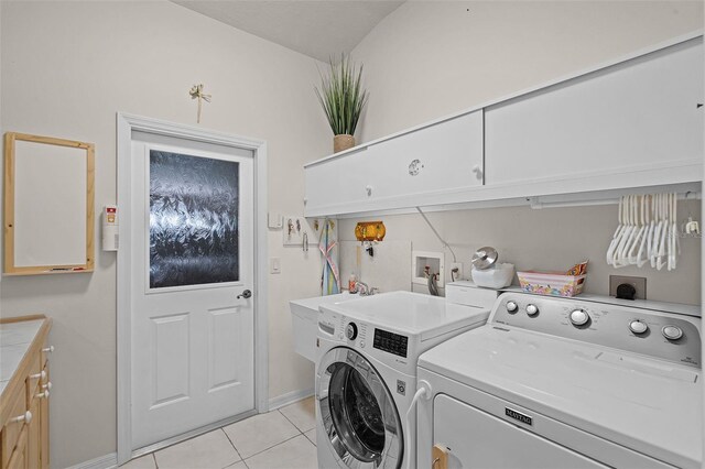 clothes washing area featuring washing machine and dryer, baseboards, cabinet space, and light tile patterned floors