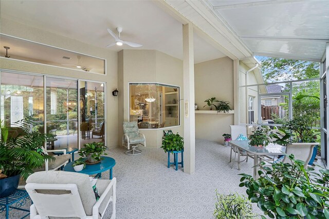 sunroom / solarium with carpet floors, a ceiling fan, and lofted ceiling
