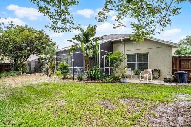 back of house featuring a lawn, a patio, stucco siding, and fence