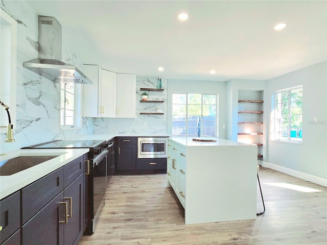 905 W 11th Ave, Mount Dora, FL 32757 - kitchen featuring wall chimney range hood, open shelves, white cabinetry, light wood-style flooring, and recessed lighting