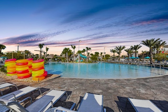 9025 Dogleg Dr, Davenport, FL 33896 - pool at dusk with a community pool, a water slide, and a patio