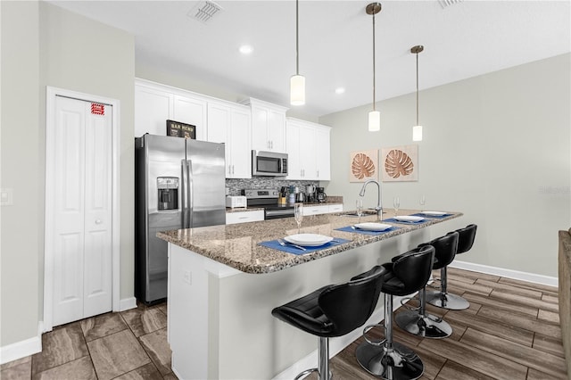 9025 Dogleg Dr, Davenport, FL 33896 - kitchen with white cabinets, visible vents, baseboards, and stainless steel appliances