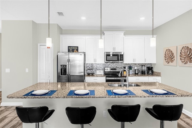 9025 Dogleg Dr, Davenport, FL 33896 - kitchen with appliances with stainless steel finishes, tasteful backsplash, a sink, and light wood-type flooring