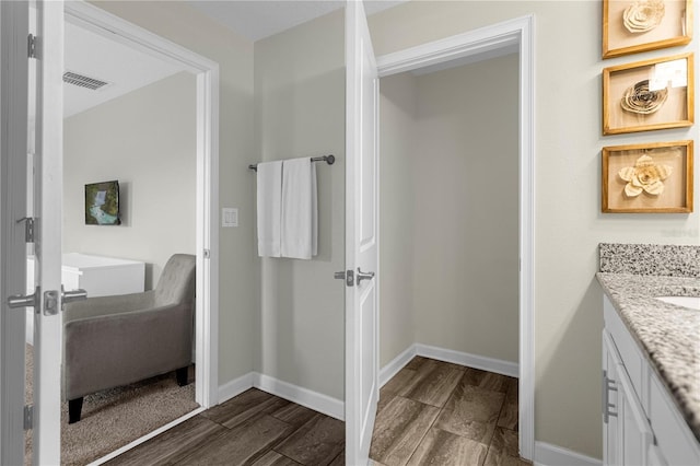 9025 Dogleg Dr, Davenport, FL 33896 - bathroom with baseboards, wood finished floors, visible vents, and vanity