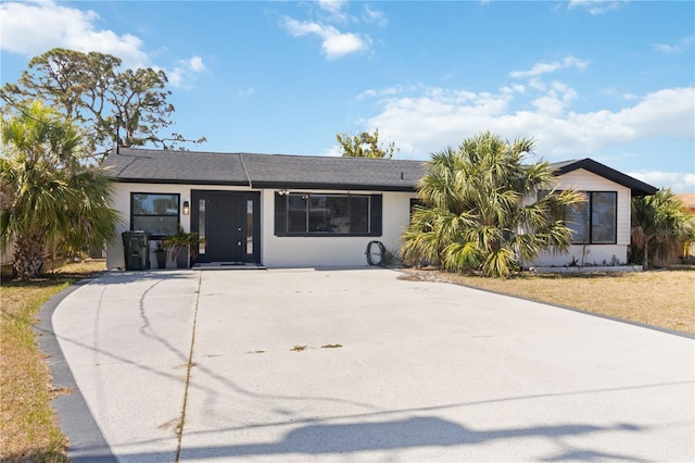 ranch-style home featuring stucco siding and concrete driveway