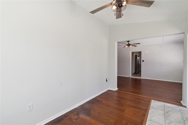 empty room with baseboards, ceiling fan, and vaulted ceiling