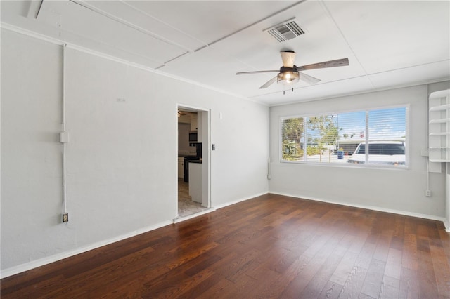 empty room featuring ceiling fan, baseboards, visible vents, and wood-type flooring