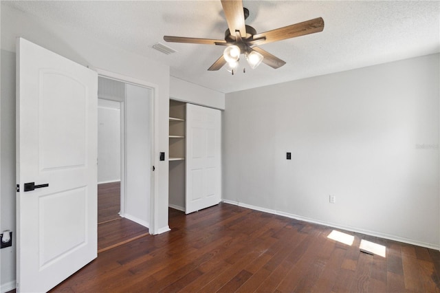 unfurnished bedroom featuring a closet, visible vents, wood finished floors, and baseboards