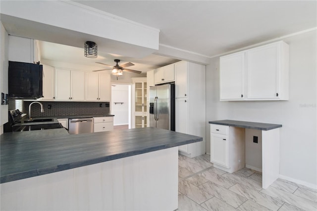 kitchen featuring decorative backsplash, ceiling fan, dark countertops, stainless steel appliances, and marble finish floor