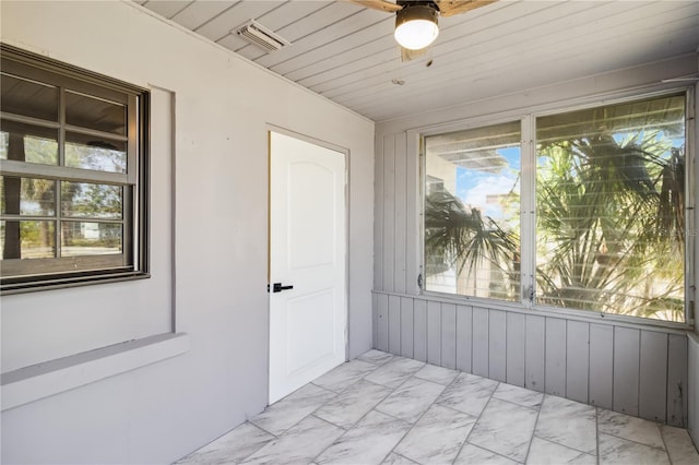 empty room featuring visible vents, plenty of natural light, and marble finish floor