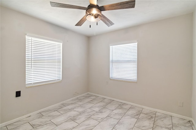 empty room with baseboards, ceiling fan, and marble finish floor