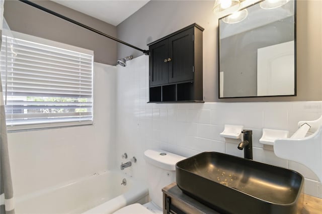 full bathroom with tile walls, a sink, shower / bathtub combination, toilet, and backsplash