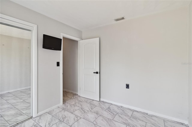 empty room with visible vents, marble finish floor, and baseboards