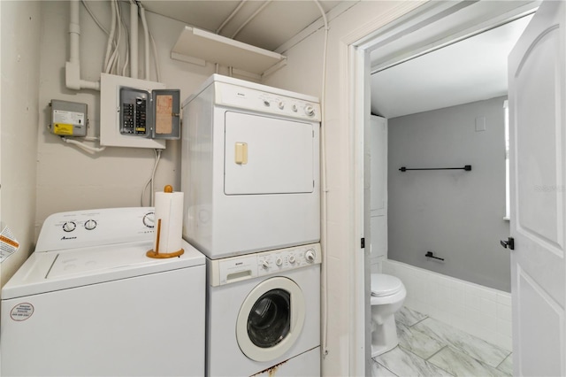 laundry room featuring marble finish floor, electric panel, stacked washer and clothes dryer, and laundry area