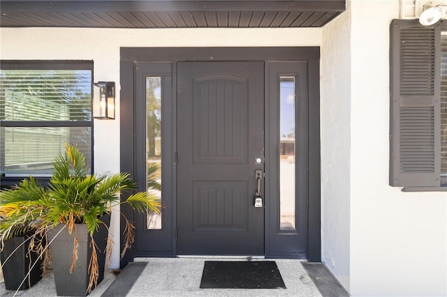 entrance to property featuring stucco siding
