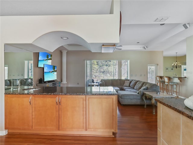 4675 Ficus Dr, Beverly Hills, FL 34465 - kitchen with a sink, a chandelier, dark stone countertops, dark wood-type flooring, and a peninsula