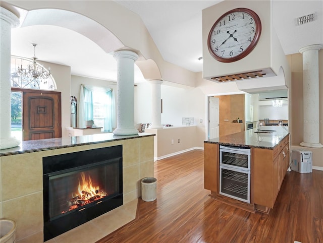 4675 Ficus Dr, Beverly Hills, FL 34465 - kitchen with ornate columns, dark stone counters, and dark wood-type flooring