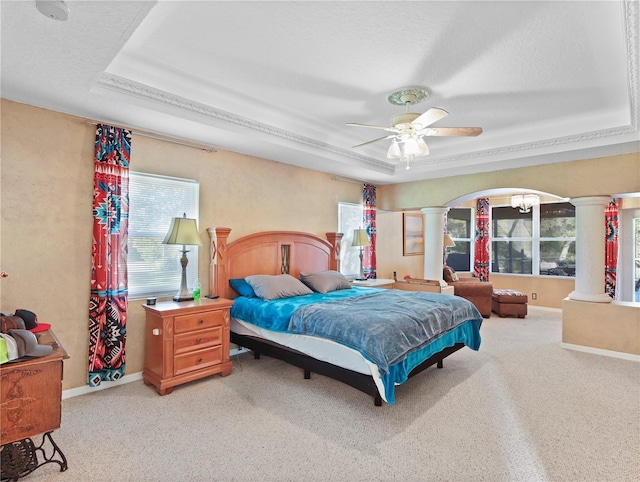 4675 Ficus Dr, Beverly Hills, FL 34465 - carpeted bedroom featuring decorative columns, a tray ceiling, a ceiling fan, baseboards, and arched walkways