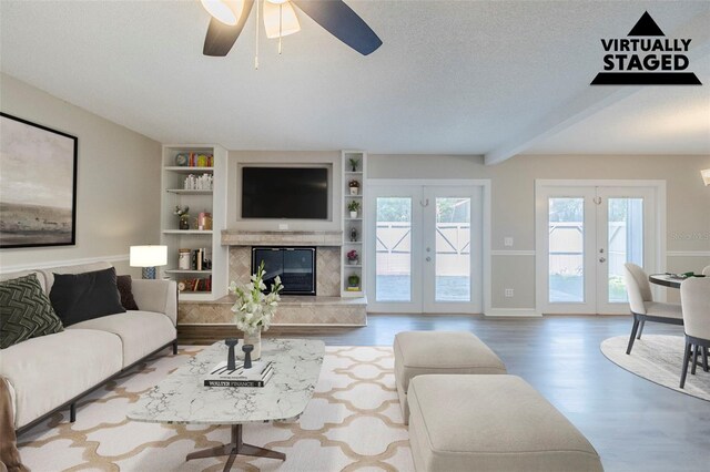 121 Primrose Dr, Longwood, FL 32779 - living area featuring wood finished floors, french doors, a ceiling fan, built in shelves, and a high end fireplace