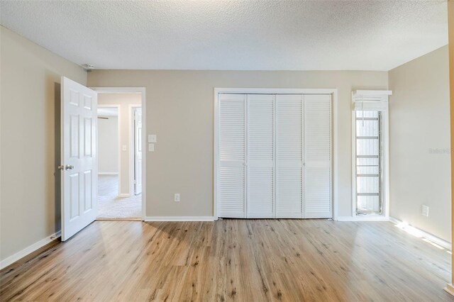 121 Primrose Dr, Longwood, FL 32779 - unfurnished bedroom with light wood-type flooring, a closet, a textured ceiling, and baseboards