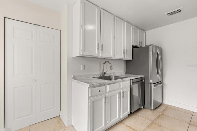 4038 Versailles Dr Unit 4038C, Orlando, FL 32808 - kitchen featuring stainless steel appliances, a sink, light tile patterned flooring, visible vents, and light countertops