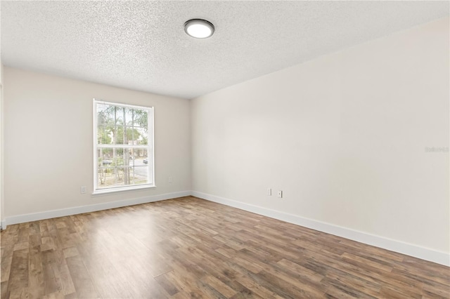 4038 Versailles Dr Unit 4038C, Orlando, FL 32808 - unfurnished room featuring wood finished floors, a textured ceiling, and baseboards