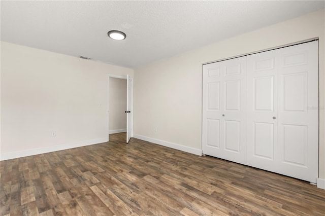 4038 Versailles Dr Unit 4038C, Orlando, FL 32808 - unfurnished bedroom with baseboards, wood finished floors, visible vents, and a closet
