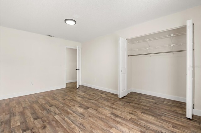 4038 Versailles Dr Unit 4038C, Orlando, FL 32808 - unfurnished bedroom with baseboards, wood finished floors, visible vents, and a closet