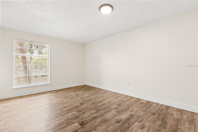 4038 Versailles Dr Unit 4038C, Orlando, FL 32808 - spare room featuring baseboards, wood finished floors, and a textured ceiling