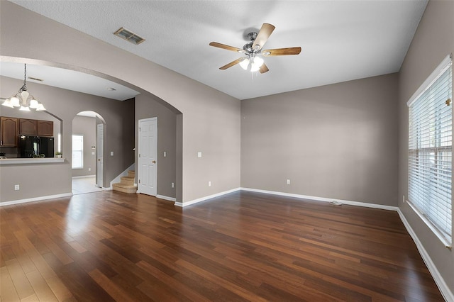16064 Old Ash Loop, Orlando, FL 32828 - spare room with visible vents, plenty of natural light, ceiling fan with notable chandelier, and dark wood-type flooring