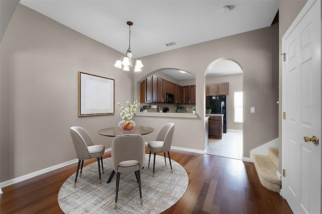 16064 Old Ash Loop, Orlando, FL 32828 - dining space with arched walkways, baseboards, and wood finished floors