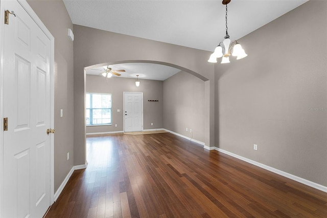 16064 Old Ash Loop, Orlando, FL 32828 - empty room featuring arched walkways, baseboards, ceiling fan with notable chandelier, and dark wood-type flooring
