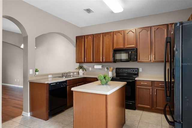 16064 Old Ash Loop, Orlando, FL 32828 - kitchen with visible vents, a sink, light tile patterned floors, light countertops, and black appliances