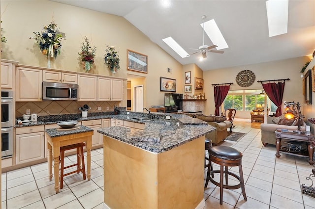 1714 Sweetwater W Cir, Apopka, FL 32712 - kitchen with a kitchen breakfast bar, a skylight, open floor plan, light tile patterned flooring, and appliances with stainless steel finishes