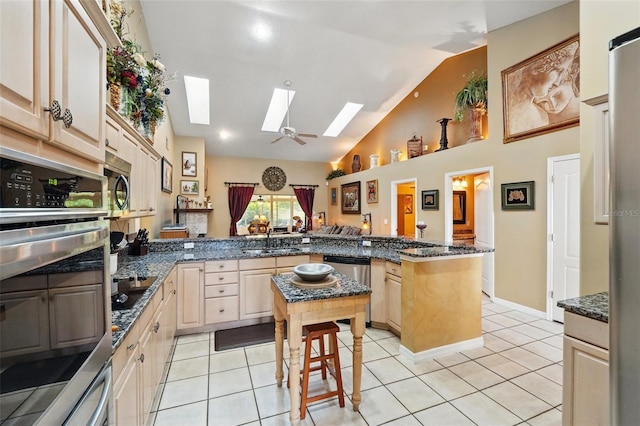 1714 Sweetwater W Cir, Apopka, FL 32712 - kitchen featuring light brown cabinets, a sink, a skylight, a peninsula, and appliances with stainless steel finishes