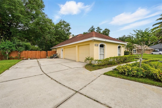 1714 Sweetwater W Cir, Apopka, FL 32712 - view of home's exterior with fence, stucco siding, a chimney, and a garage