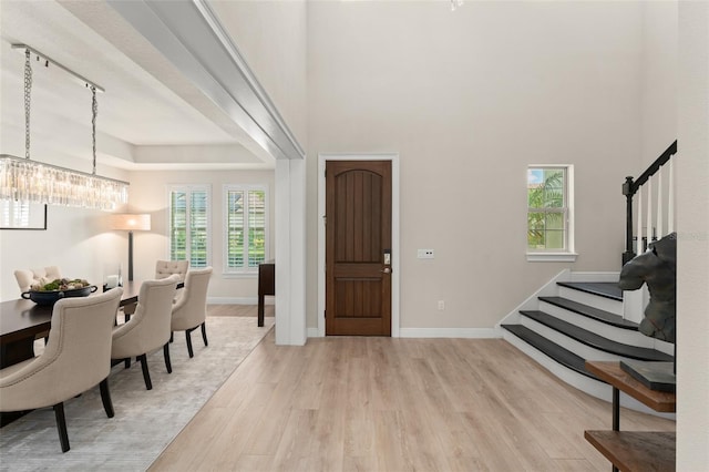8017 Chilton Dr, Orlando, FL 32836 - foyer with stairway, light wood-type flooring, a chandelier, baseboards, and a high ceiling