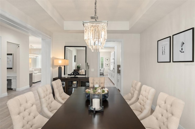 8017 Chilton Dr, Orlando, FL 32836 - dining room with a chandelier, a raised ceiling, light wood-style floors, and baseboards