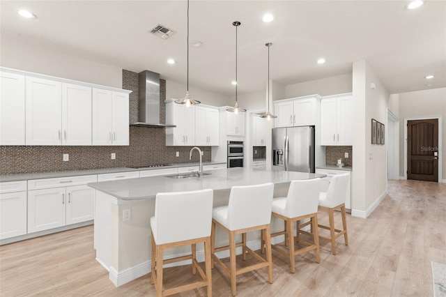 8017 Chilton Dr, Orlando, FL 32836 - kitchen featuring stainless steel appliances, wall chimney range hood, a sink, a kitchen island with sink, and tasteful backsplash